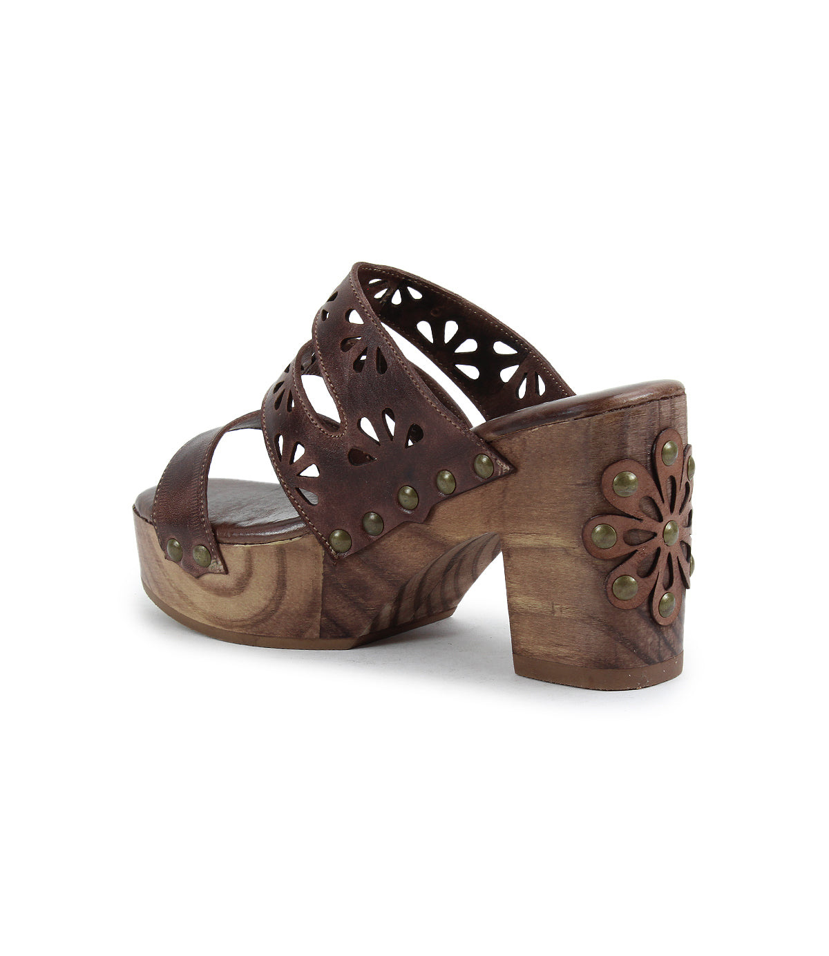The Bed Stu Kreep is a 70's-inspired brown platform sandal featuring a natural wooden heel with floral cutout design on its straps, adorned by decorative metal studs along the edges.