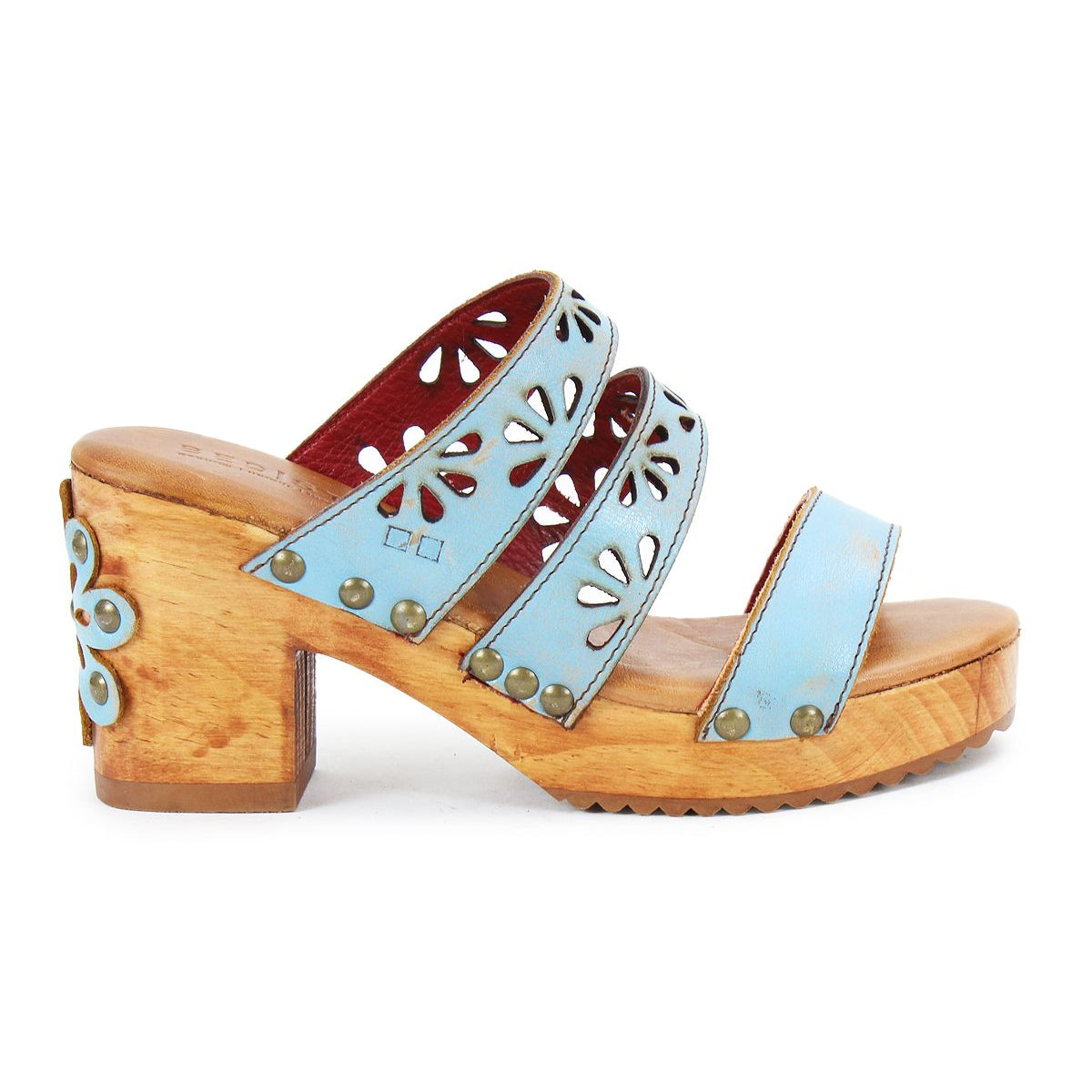 The Bed Stu Kreep is a wooden platform sandal with light blue leather straps and 70's-inspired floral cutouts, highlighted by a small flower detail on the heel.