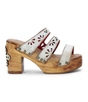 The Kreep by Bed Stu is a 70's-inspired wooden platform sandal with three white leather straps, featuring floral cutouts and metal studs.