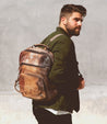 A man wearing a Bed Stu Lafe brown leather backpack.