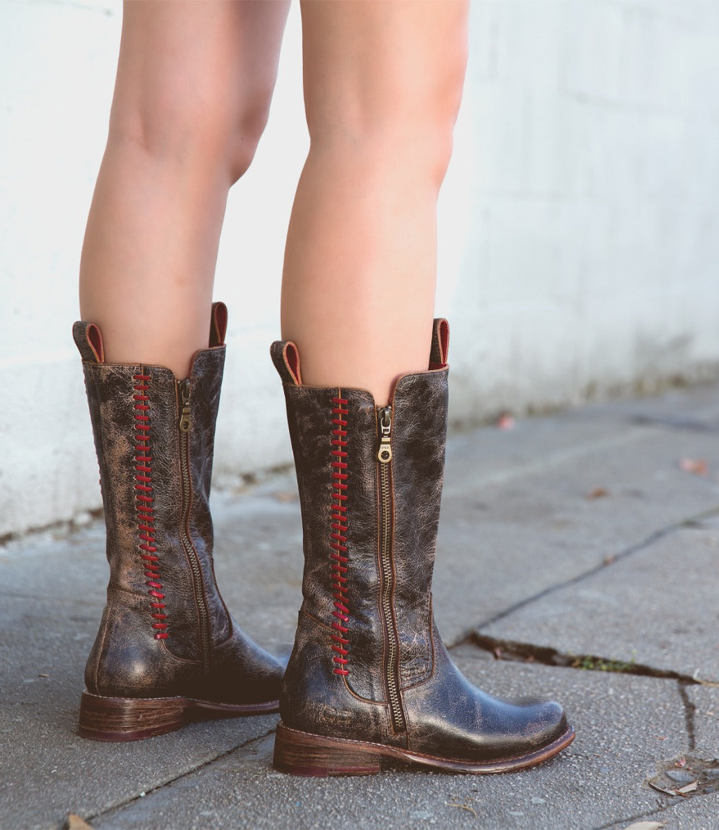 A woman wearing a pair of brown Bed Stu Latifah cowboy boots.