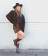 A woman wearing a pair of brown Bed Stu Latifah cowboy boots.