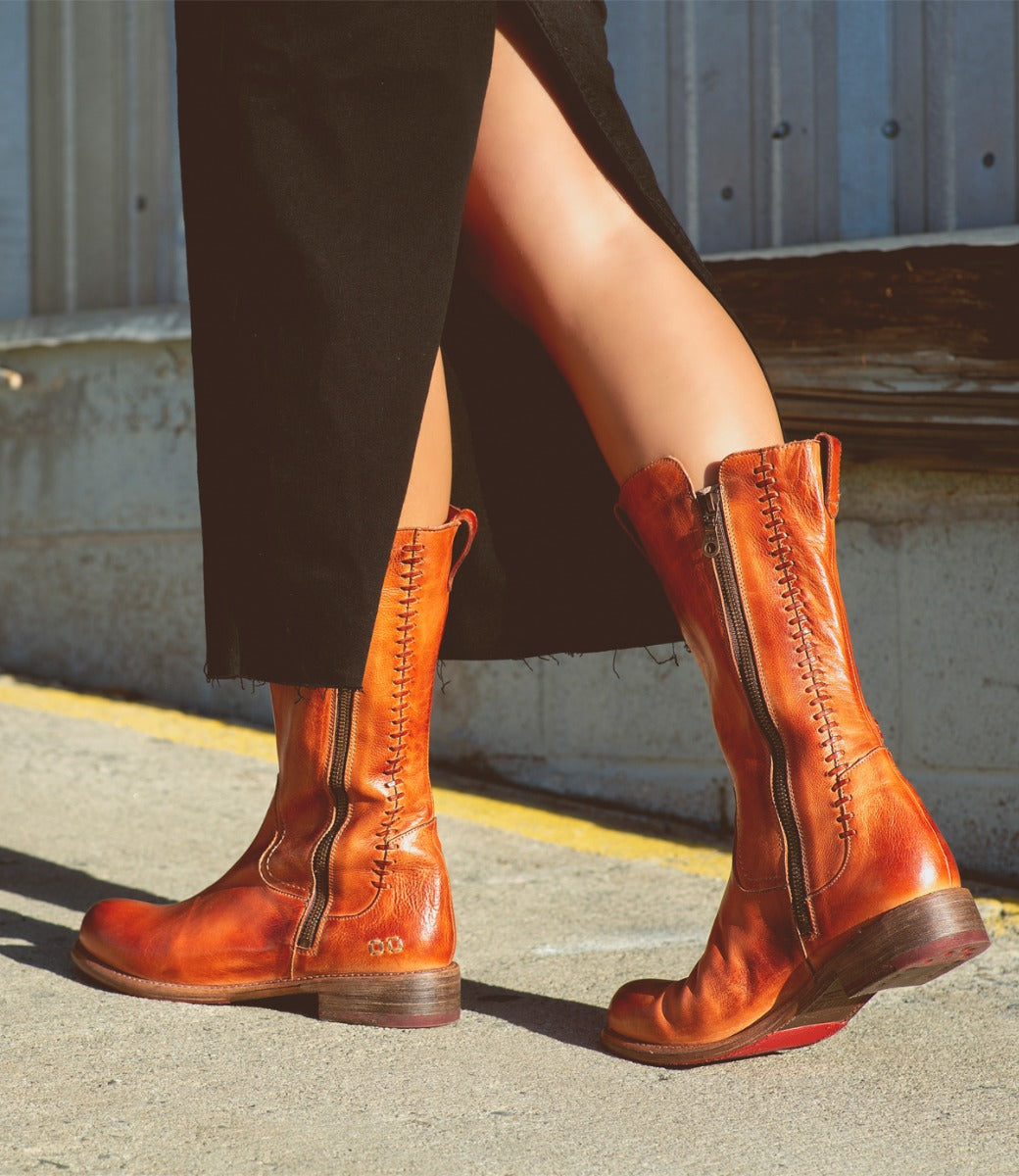 A woman wearing Bed Stu Latifah brown leather boots and a black skirt.