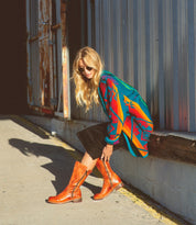 A woman wearing Bed Stu Latifah brown leather boots and a black skirt.