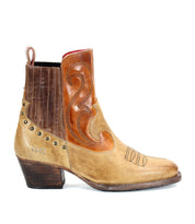 The Bed Stu League is a single brown and tan leather cowboy boot with rugged charm, featuring playful stitching details, metal studs, and a low heel, shown in a side profile view.