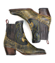The Bed Stu League Western short boots, crafted from distressed brown and black leather, exude rugged charm with their playful stitching, side elastic panels, and wooden heels.