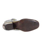 A close-up view of the sole of the Bed Stu League, a brown leather Western short boot, showcasing its playful stitching details and slight wear, exuding rugged charm.