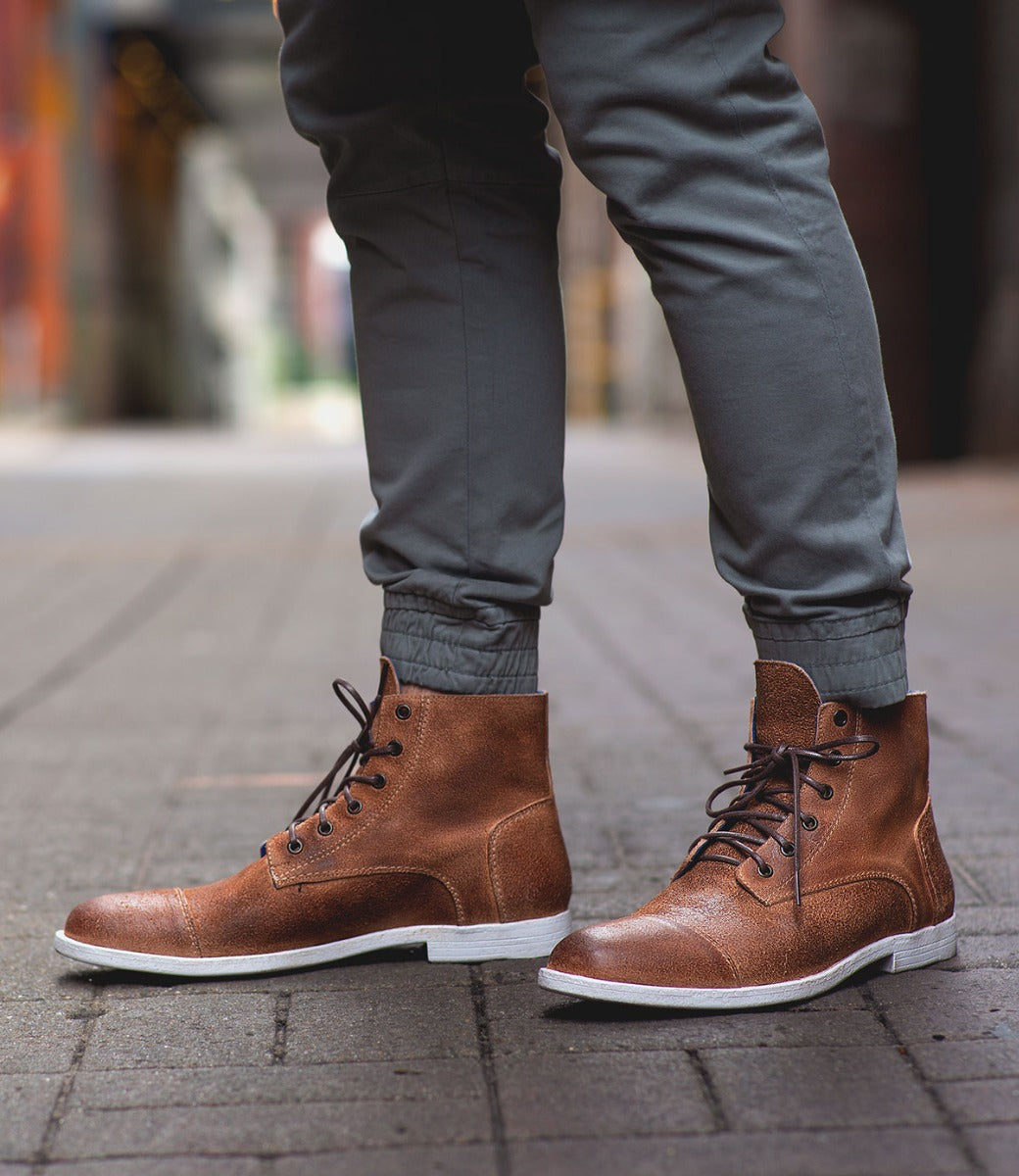 A man wearing a pair of Bed Stu Leonardo brown leather boots.