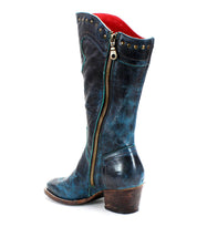 Introducing the Limit by Bed Stu: a blue leather Western mid-calf boot, complete with a mid-height heel. This stylish boot features a convenient zipper on the side, metal studs adorning the top edge, and elegant floral stitching. It is beautifully showcased against a white background.