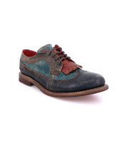 The Bed Stu Lita K is a worn leather wingtip oxford with blue, brown, and red panels, brogue detailing, red laces, a wingtip toe, and a low heel.