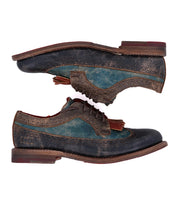 Two worn, vintage-style Bed Stu Lita K leather dress shoes with wingtip toe and classic derby design in dark blue, teal, and brown are stacked sole to sole, facing opposite directions.