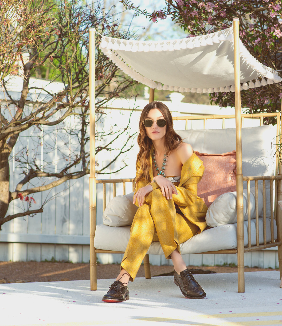 A woman sitting on a chair in a yellow suit wearing Bed Stu Lita K II.