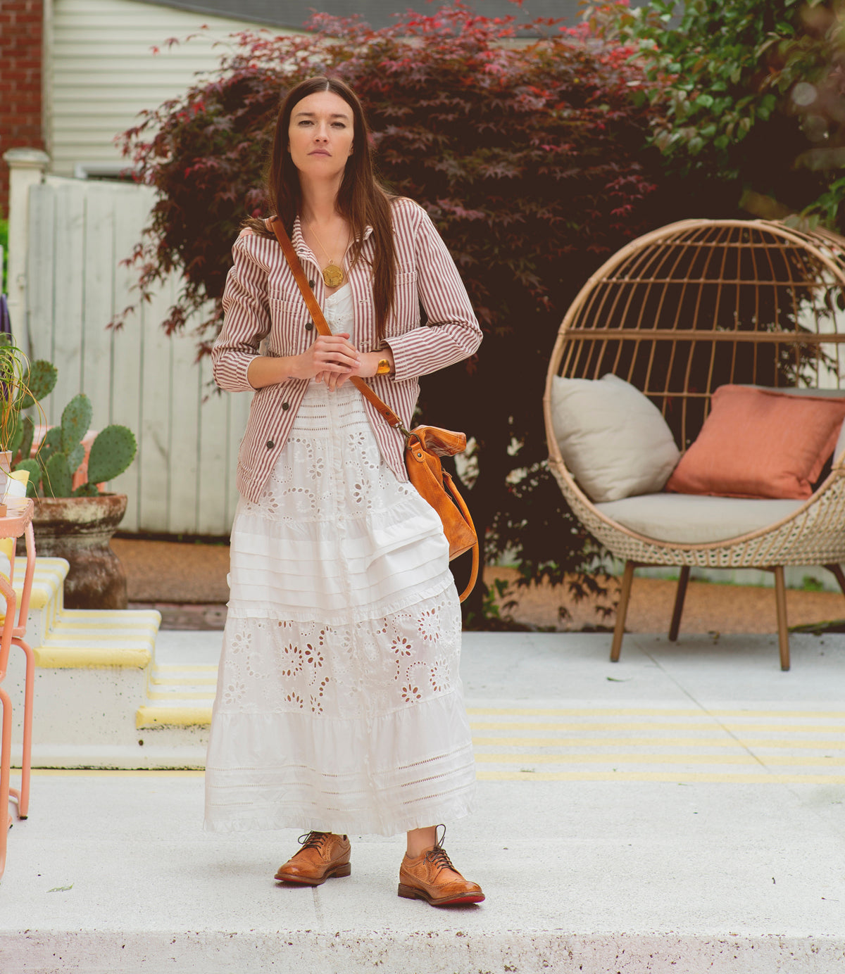 A woman in a white dress standing on a patio wearing the Lita K II by Bed Stu.