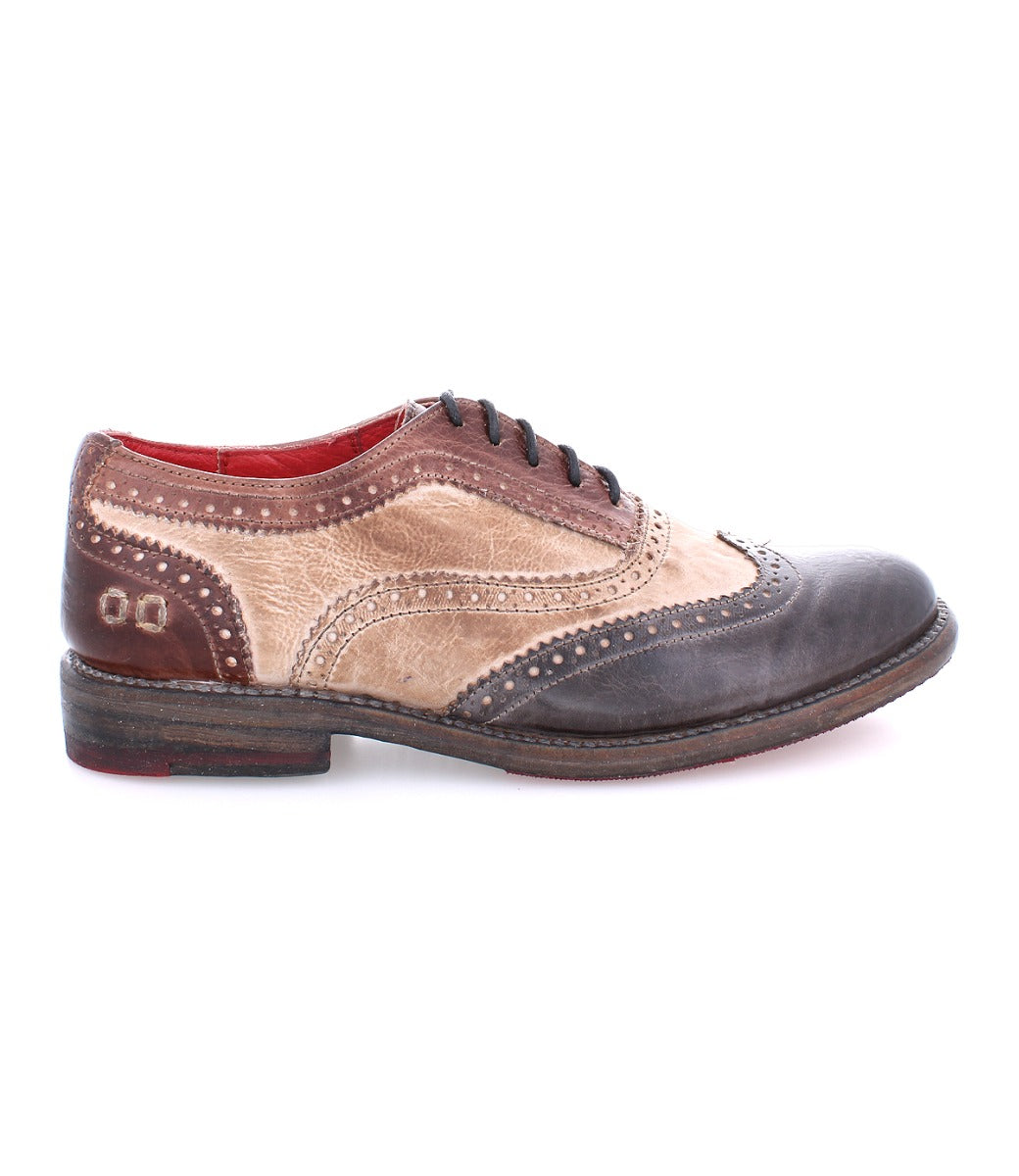 A woman's wingtip oxford shoe, the Lita by Bed Stu, with brown and black detailing.