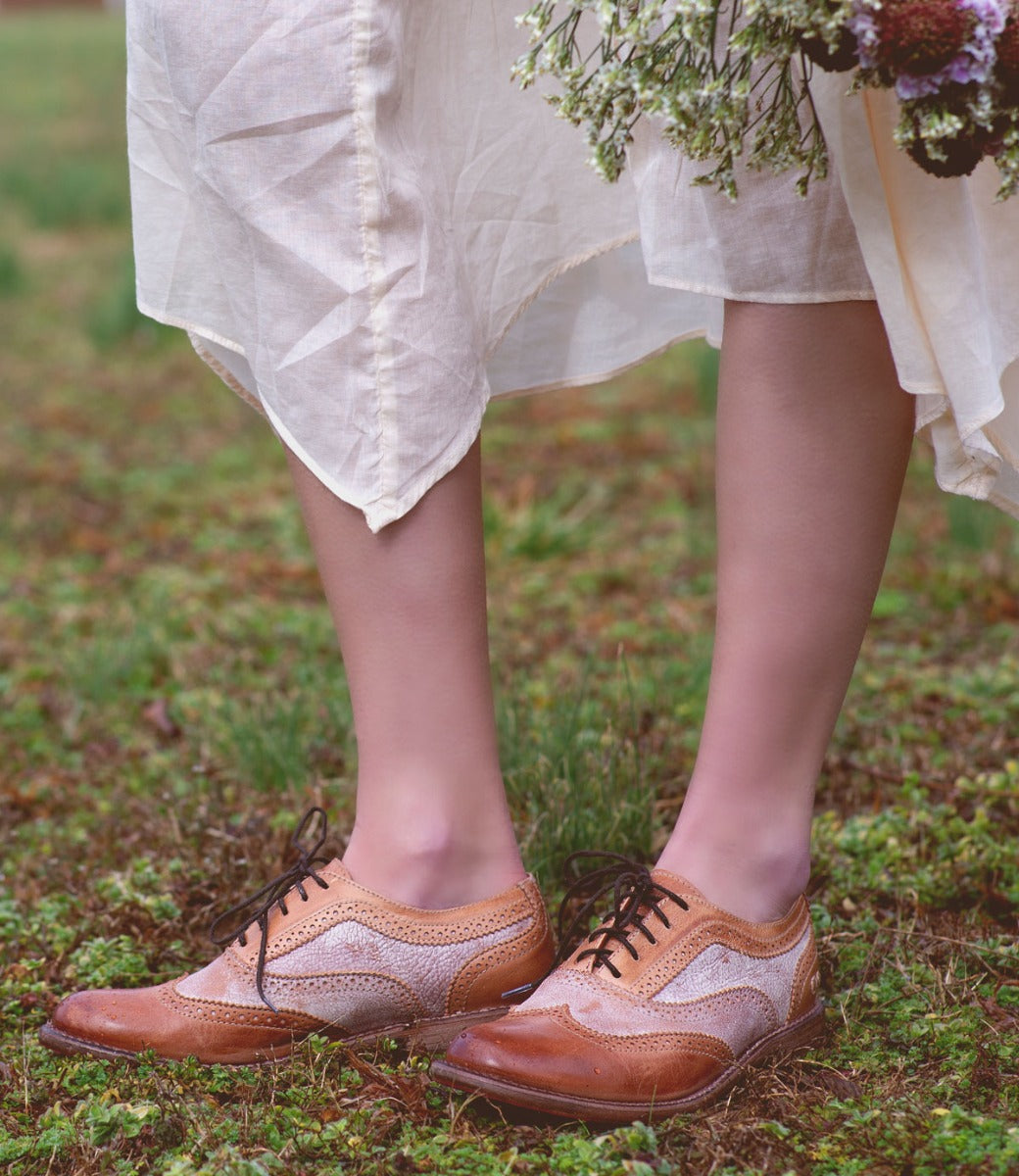 A woman wearing a white dress and a pair of Bed Stu Lita shoes.