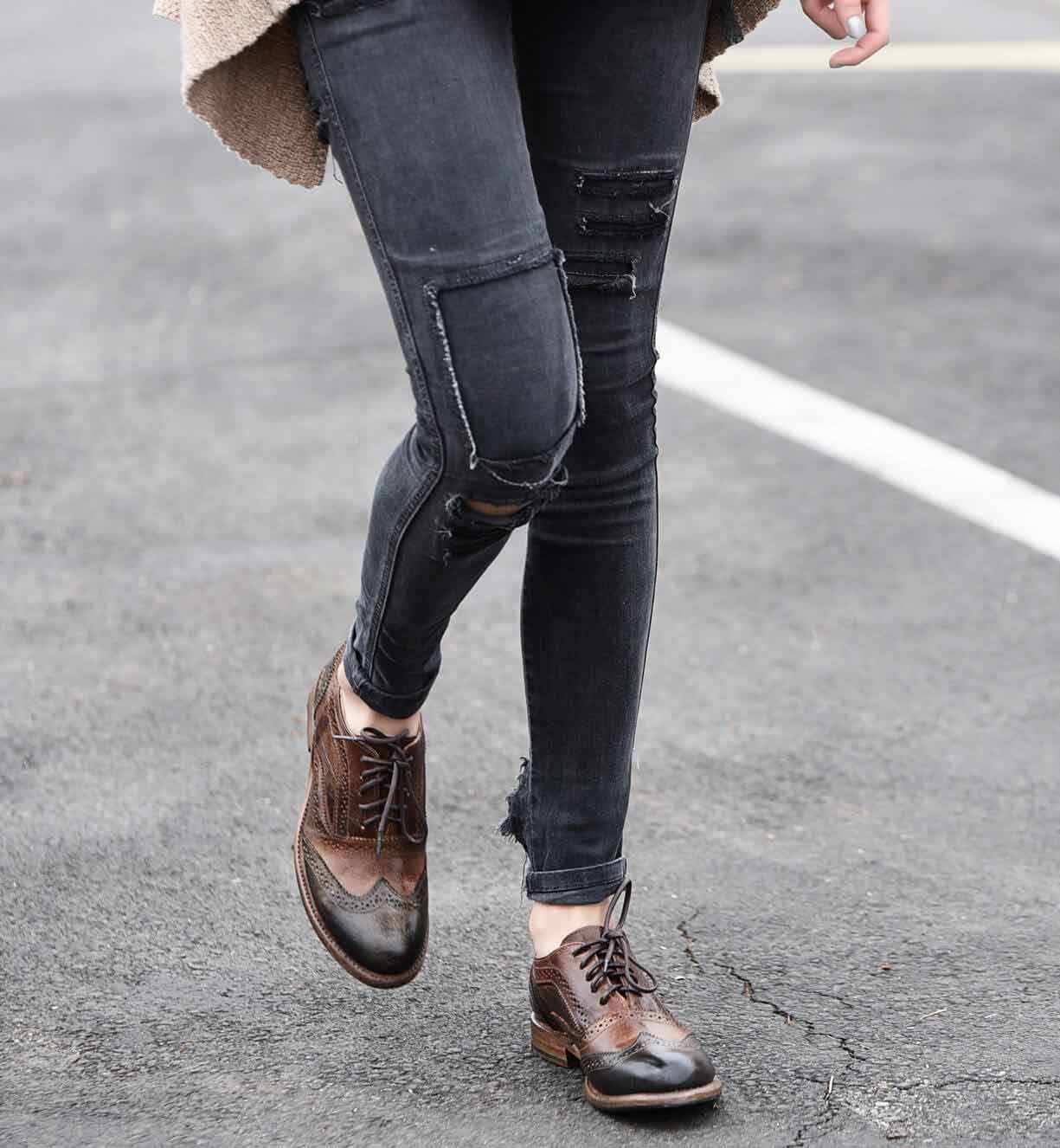 A woman wearing Bed Stu Lita shoes, ripped jeans and a sweater.