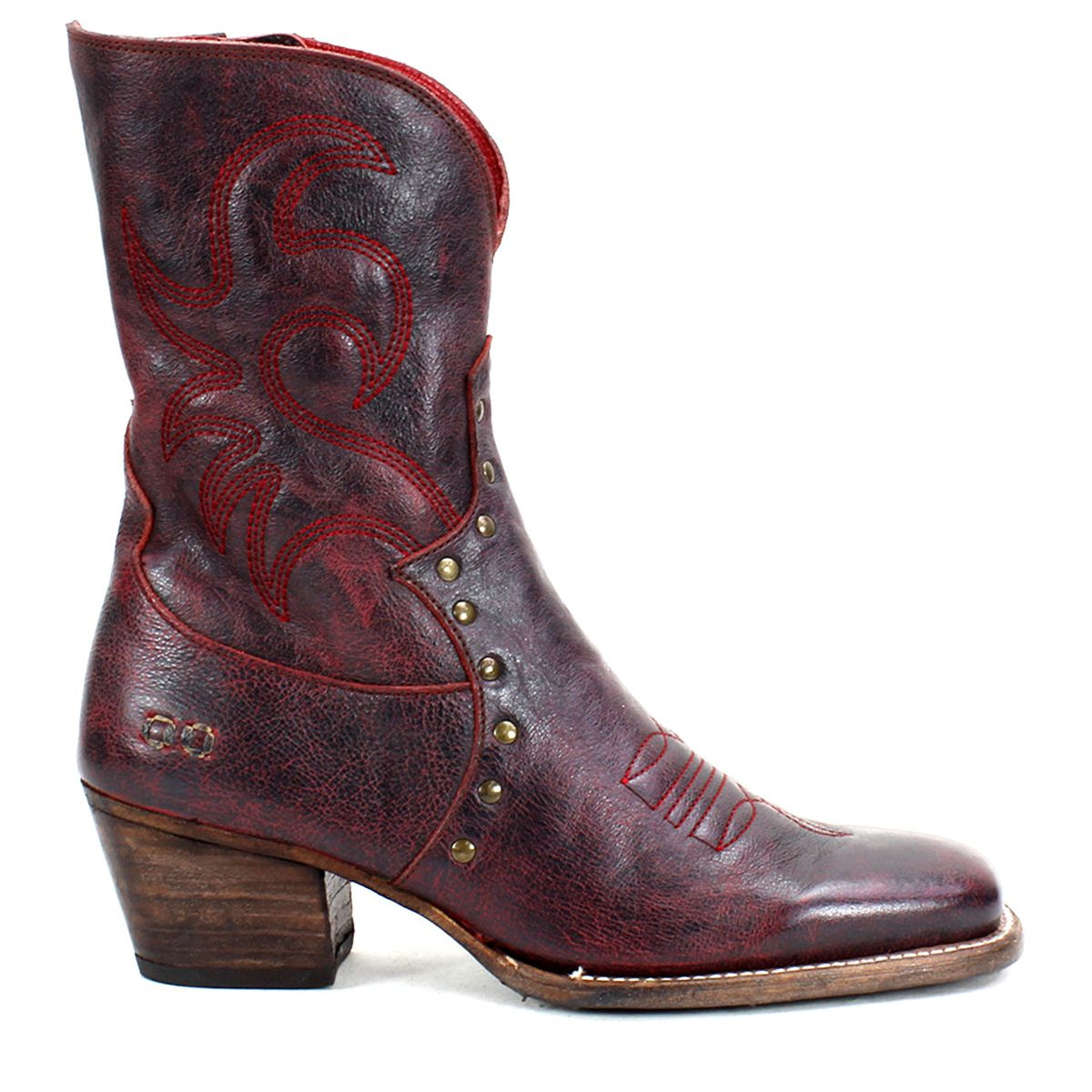 The Bed Stu "Locate" boot, featuring flame-like stitching, brass studs, and a wooden heel in brown leather, is displayed against a white background.