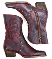 A pair of "Locate" Western boots by Bed Stu, crafted from brown leather and featuring flame-like stitching, metal studs, and side zippers, elegantly viewed from the side and top.