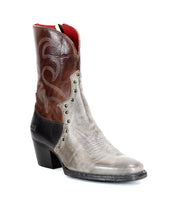 The "Locate" Western boot by Bed Stu is crafted from leather and features flame-like stitching, metallic rivets, and a side zipper. The design showcases an eye-catching blend of brown, grey, and black color blocks.