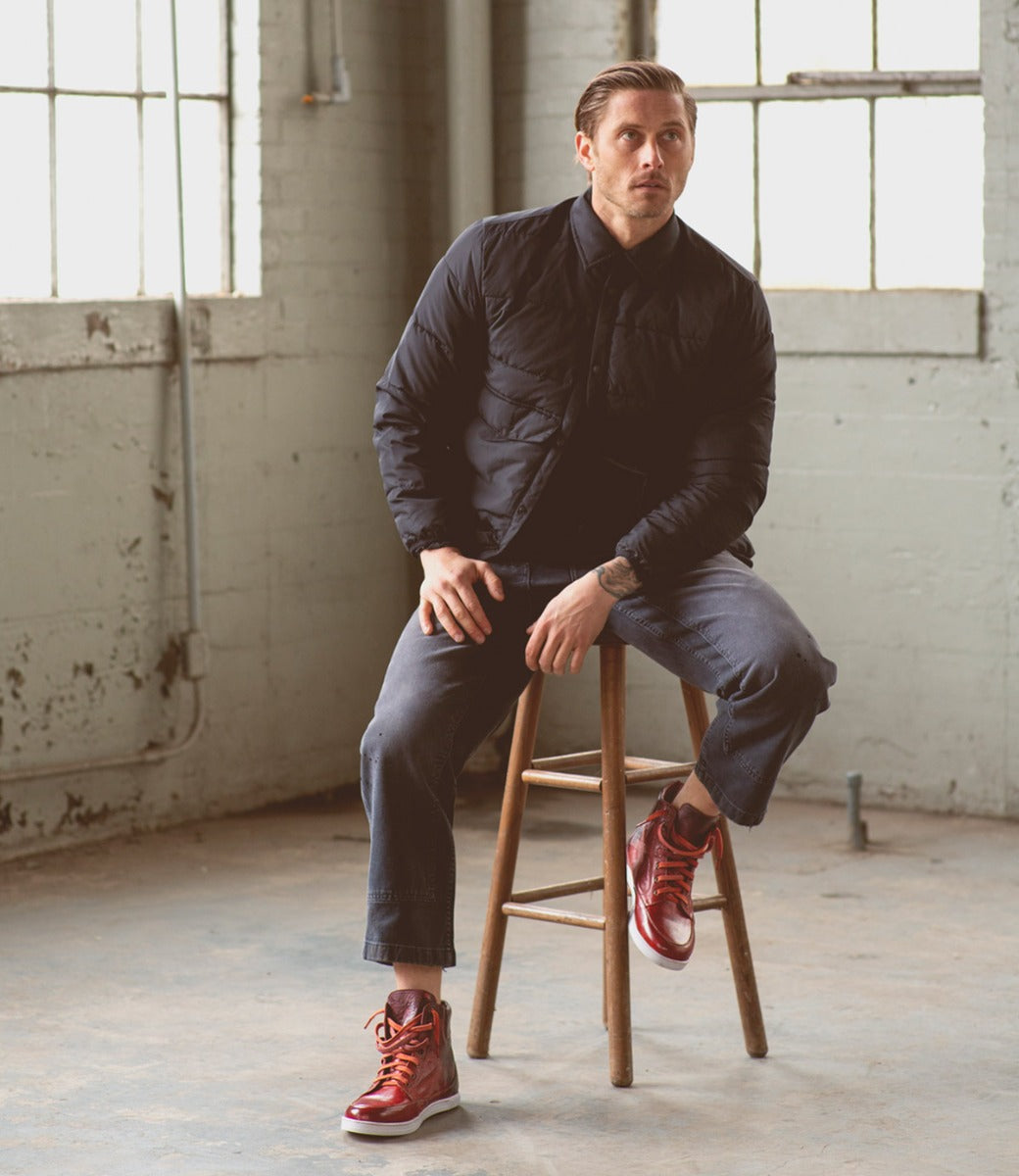 A man sitting on a Lordmind stool in a warehouse.