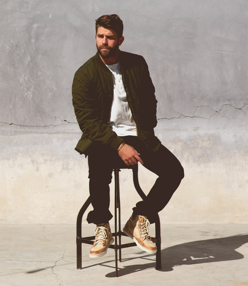 A man sitting on a Lordmind stool next to a wall.