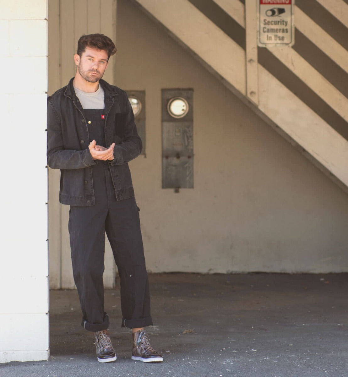 A man wearing Lordmind overalls and a Bed Stu jacket.