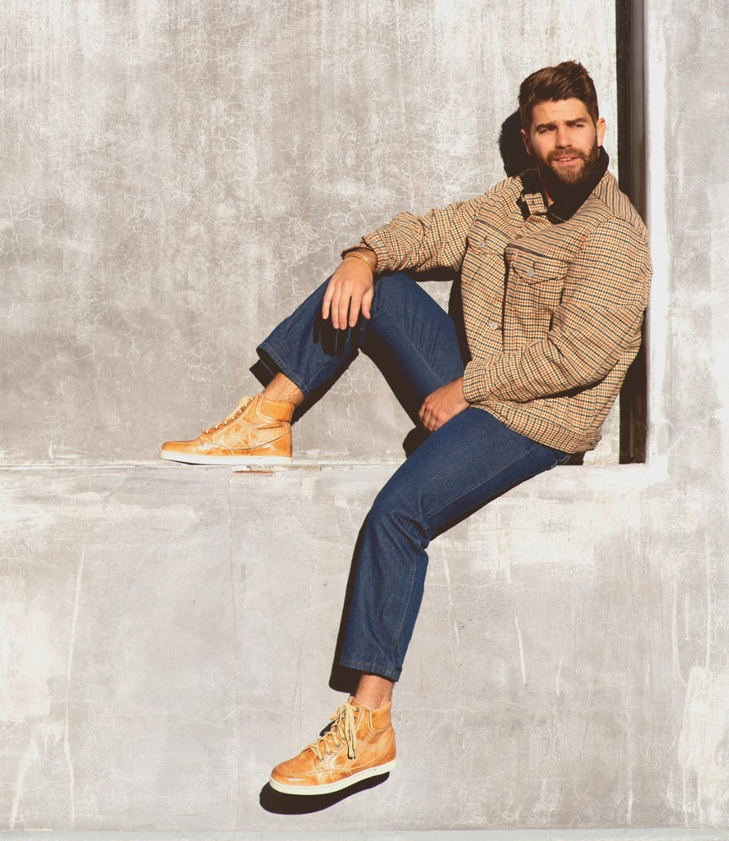 A man with a Lordmind beard sitting on a concrete wall. (Brand Name: Bed Stu)