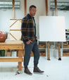 A man standing in front of a Bed Stu Lordmind painting in a studio.