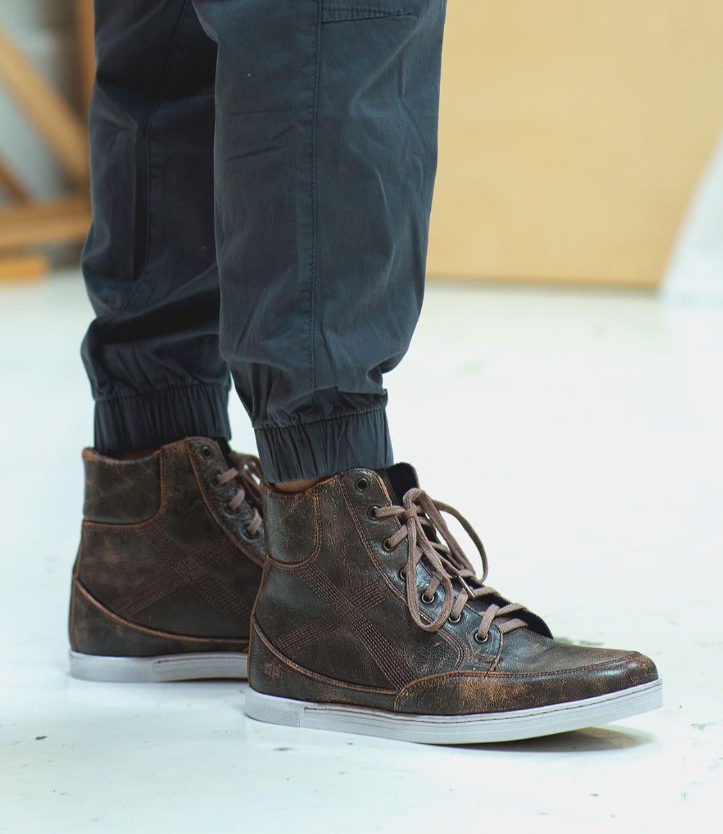 A man wearing a pair of Bed Stu Lordmind brown leather sneakers.