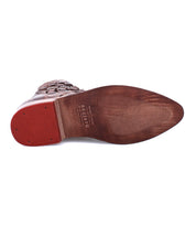 A pair of Loretta shoes by Bed Stu with red soles.
