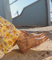 A woman's feet in a pair of Bed Stu Loretta sandals.