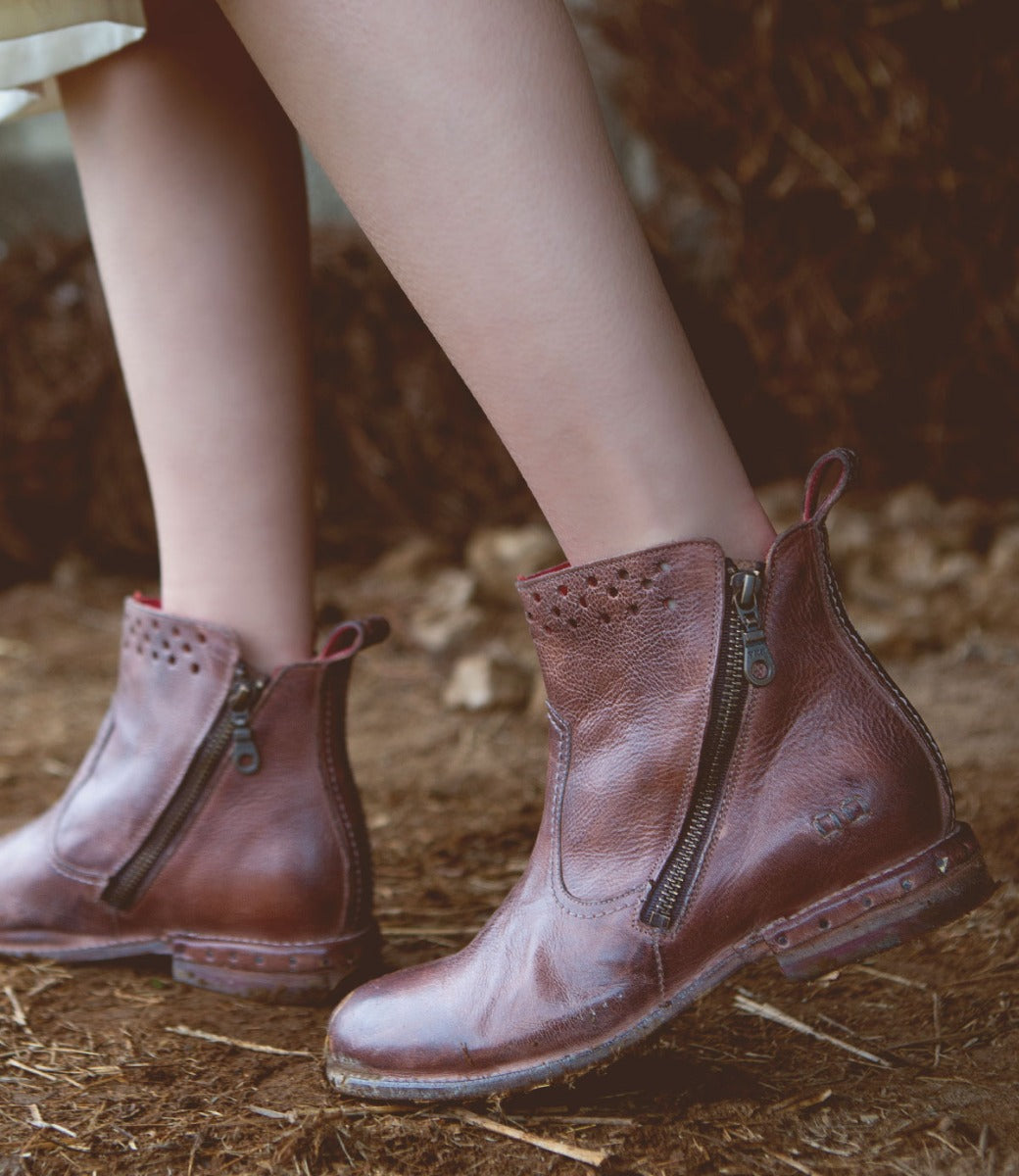 A woman's feet in a pair of Bed Stu Lotus boots.