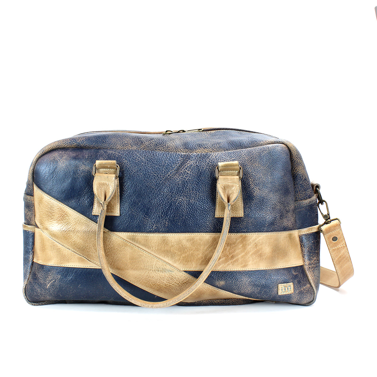 The **Bed Stu Luke**, a blue and tan leather duffle bag with two handles and an adjustable crossbody strap, featuring a diagonal tan stripe design, makes the perfect travel companion.