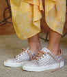 A woman wearing a yellow dress and Bed Stu sneakers.