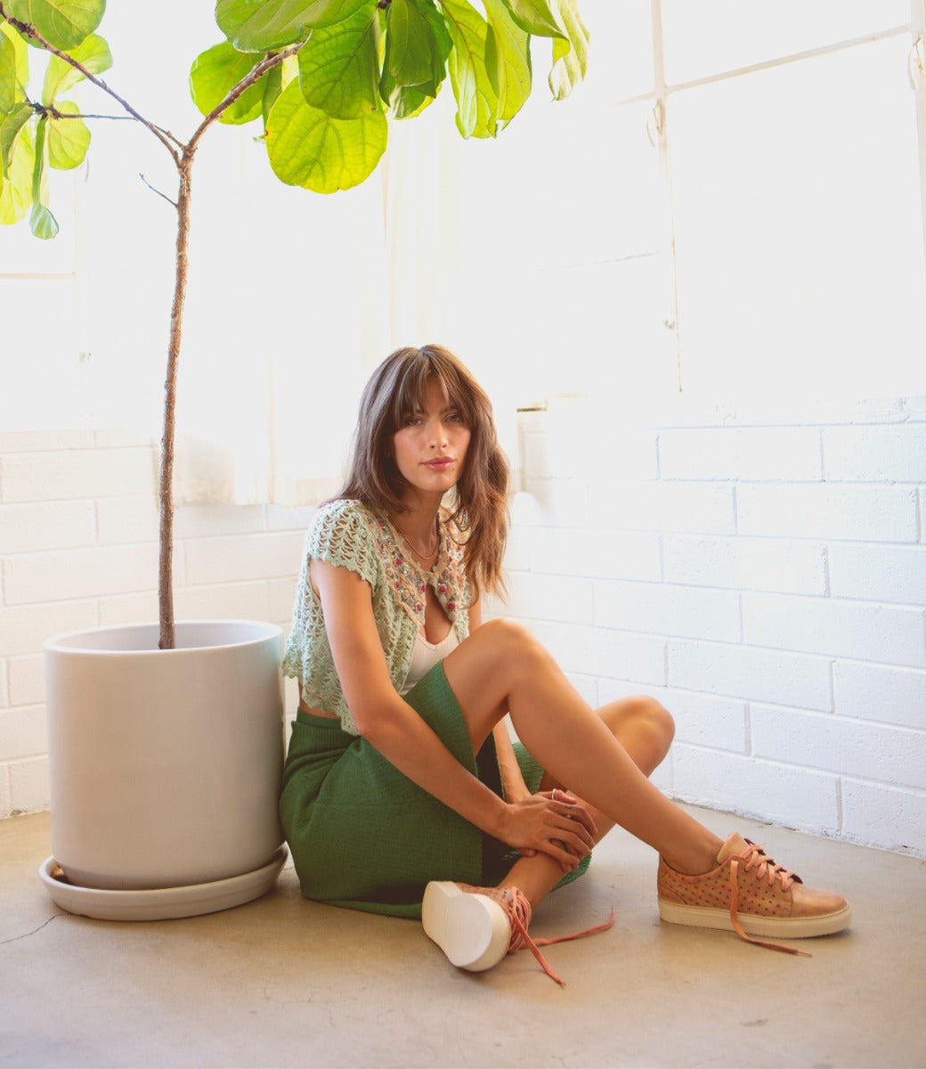 A woman sitting on the floor, wearing Bed Stu Lynes.