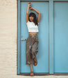 A woman leaning against a blue Bed Stu door, wearing the Manati II.