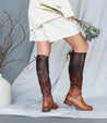 A woman wearing a pair of Bed Stu Manchester boots and a bouquet of flowers.