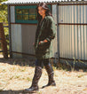 A woman in a green plaid coat standing in front of a Bed Stu Manchester III shed.