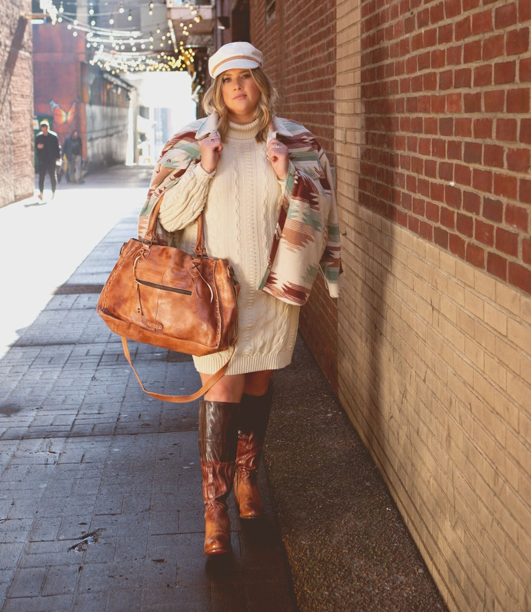 A woman wearing a Manchester Wide Calf sweater, Bed Stu boots, and a Bed Stu bag.
