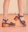 A woman's feet in a pair of Bed Stu Mantis wooden sandals.
