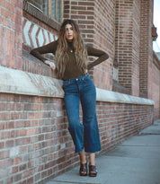 A woman in jeans and sweater wearing Marie sandals by Bed Stu.