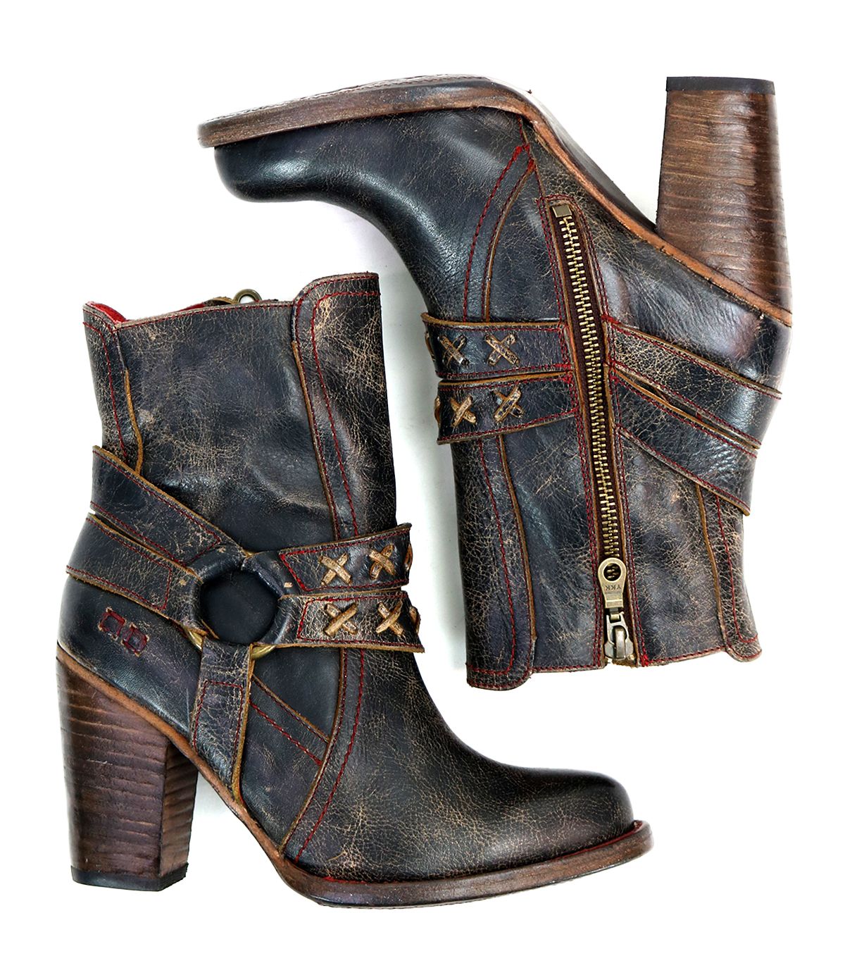 A pair of black distressed leather boots with a high heel, red stitching and o-ring harness. on the profile view. 