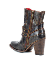 A black distressed leather boot with a high heel, red stitching and o-ring harness on the rear backside  view. 