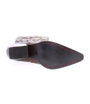 A photo showcasing the Meadow boot's sole reveals a pointed toe, black sole with red stitching, and a chunky heel. This handcrafted leather boot from Bed Stu also features stunning floral inlay designs that add an extra touch of elegance.