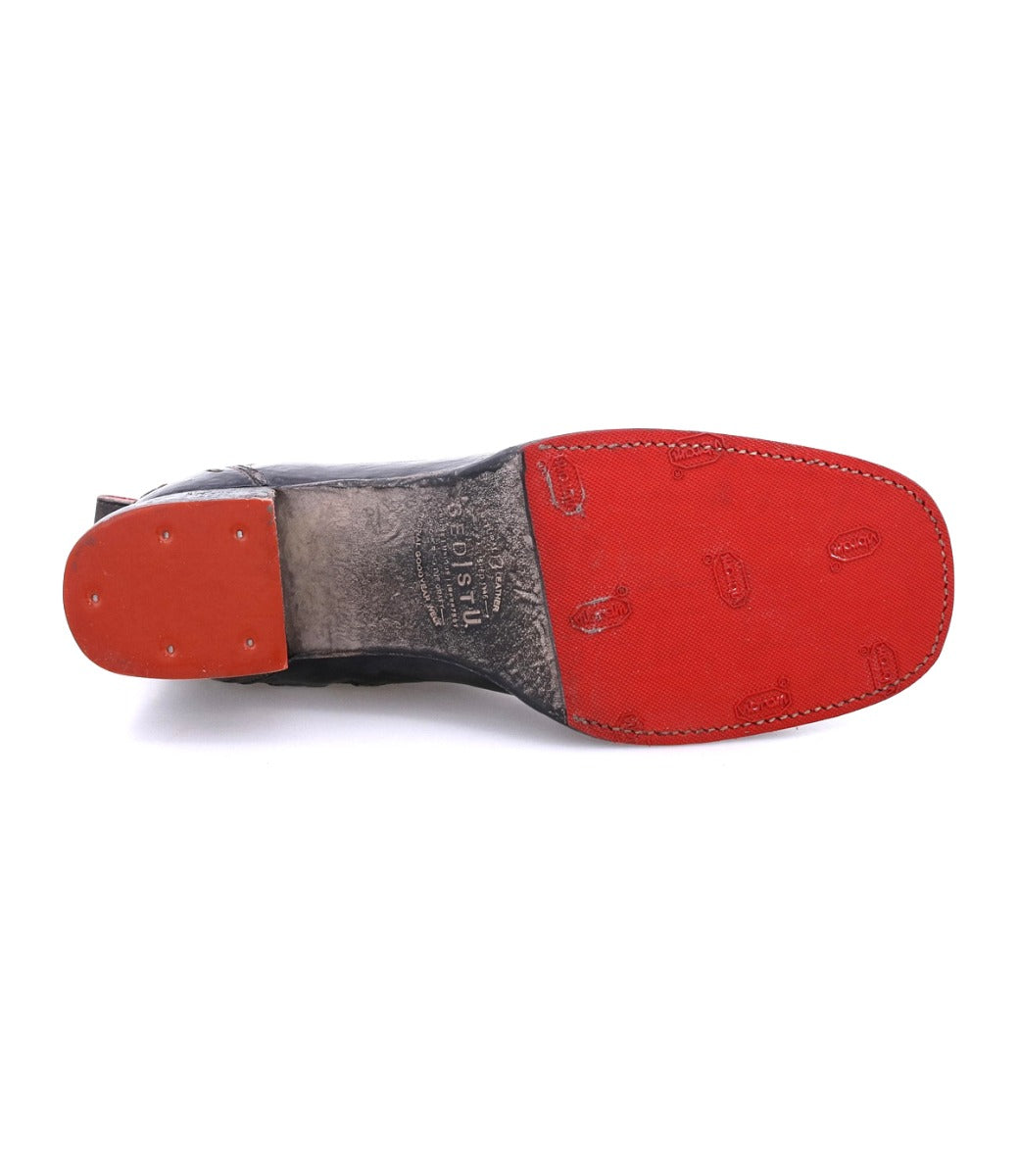 A black and red Merryli shoe with a red sole from Bed Stu.