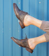 A woman's feet in a pair of Bed Stu Mickie shoes.