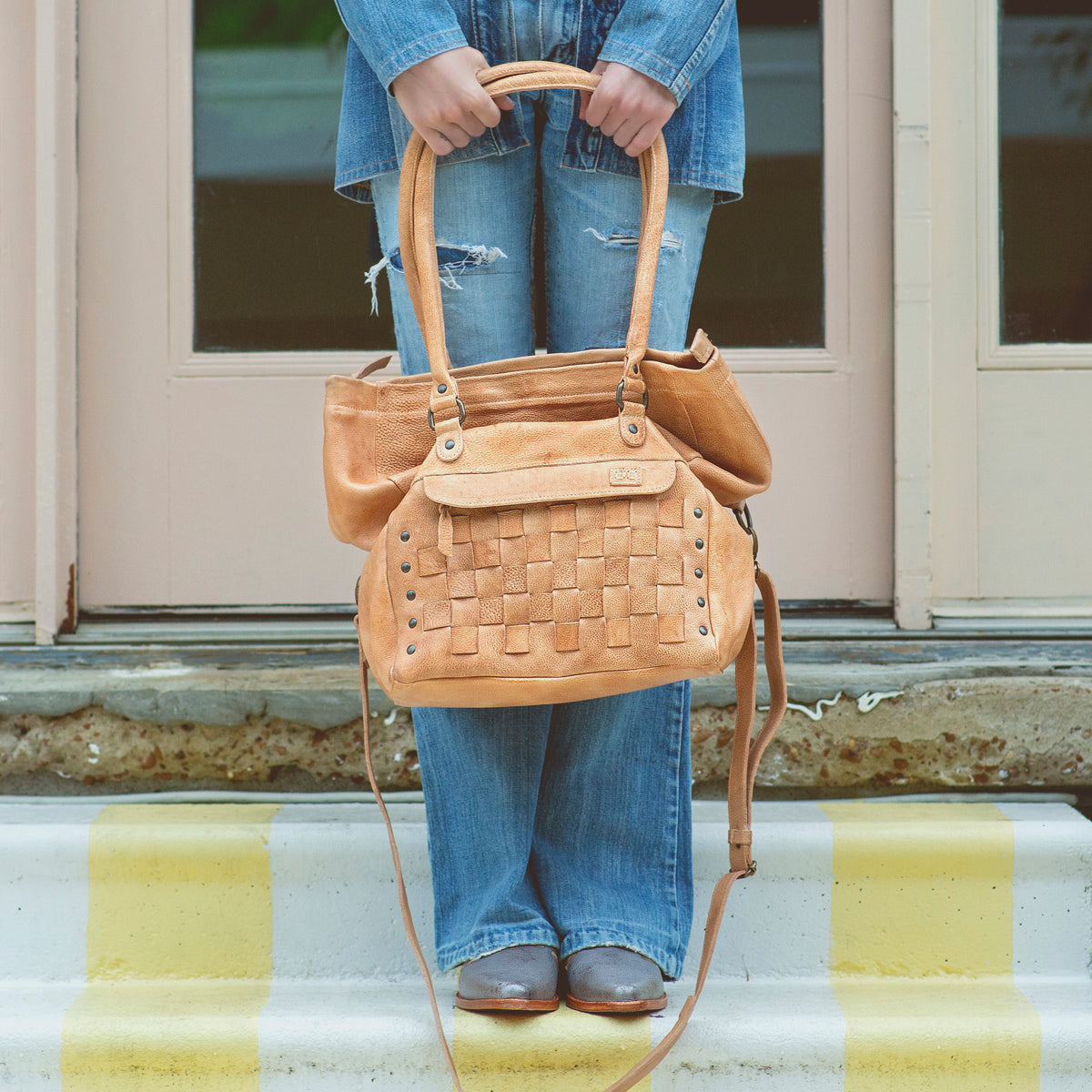 A woman holding a Miriam handbag by Bed Stu.