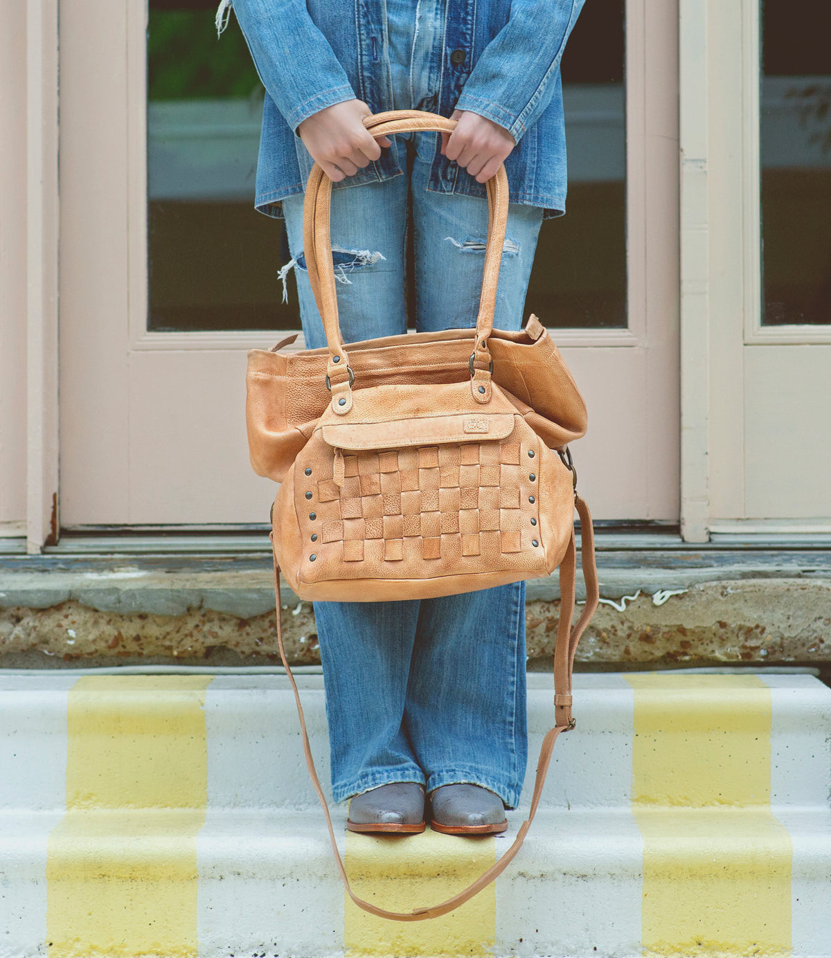 A woman holding a Miriam handbag by Bed Stu.