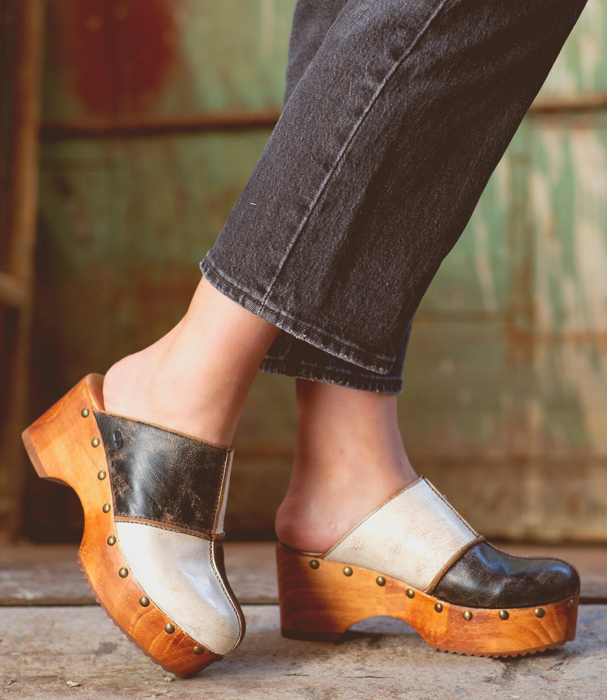 A woman wearing Bed Stu's eco-friendly black and white Mista clogs.