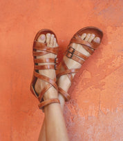 A woman wearing Bed Stu Miya tan leather sandals.
